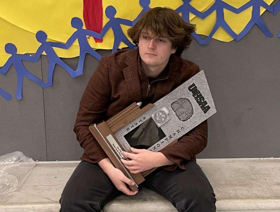 Senior Cody Rutkowski posing with the 5A second place state trophy. 